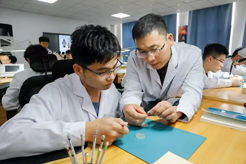 师生共同分析已装配完成的计时机芯工作状态。2026世界杯官网供图